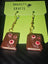 Necronomicon Book of the Dead earrings with brown textured polymer clay and red eye designs, hanging from gold hooks, gothic style jewelry