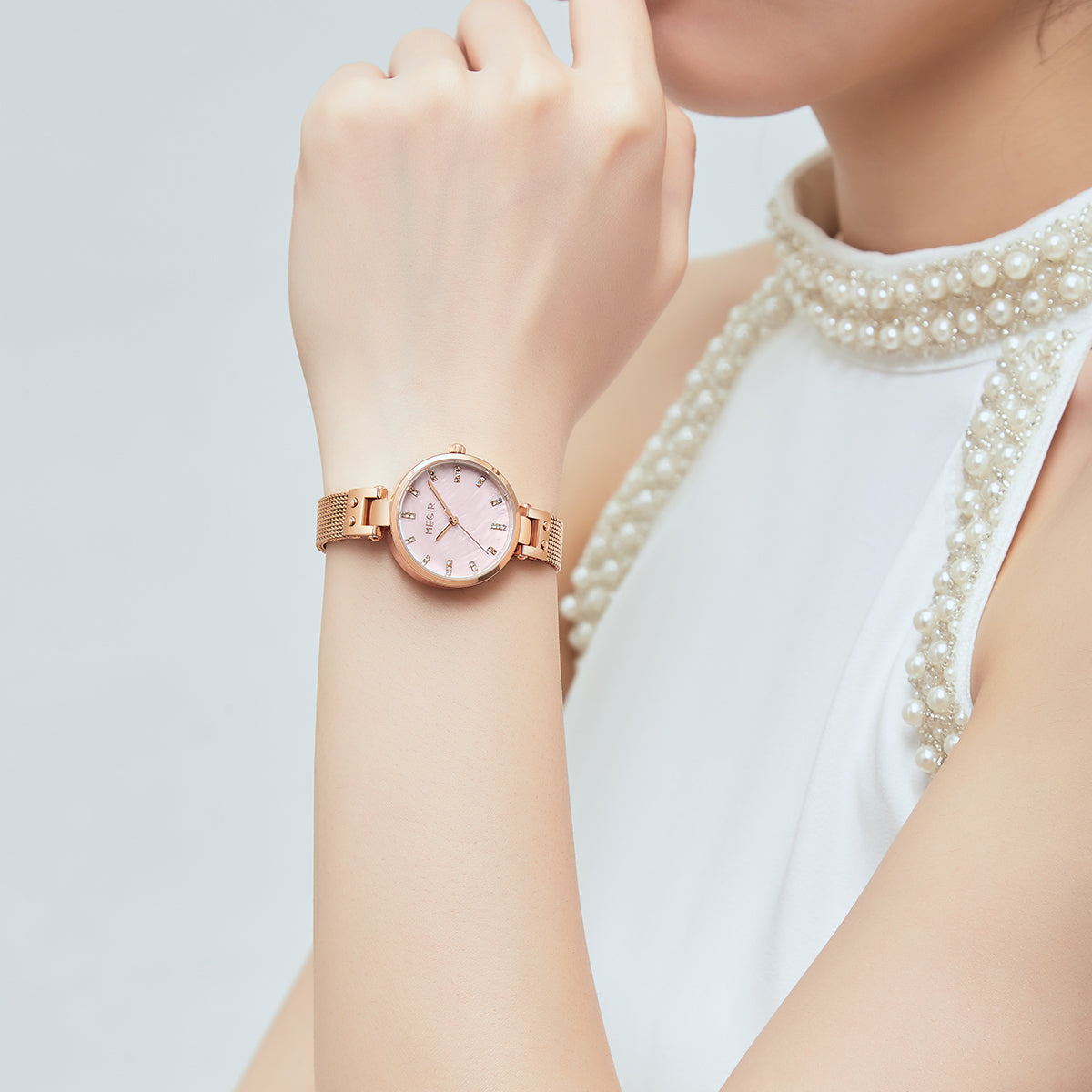 Elegant women's luxury quartz wristwatch with pink mother-of-pearl dial, crystal hour markers, rose gold mesh band, and water resistance