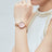 Elegant women's luxury quartz wristwatch with pink mother-of-pearl dial, crystal hour markers, rose gold mesh band, and water resistance