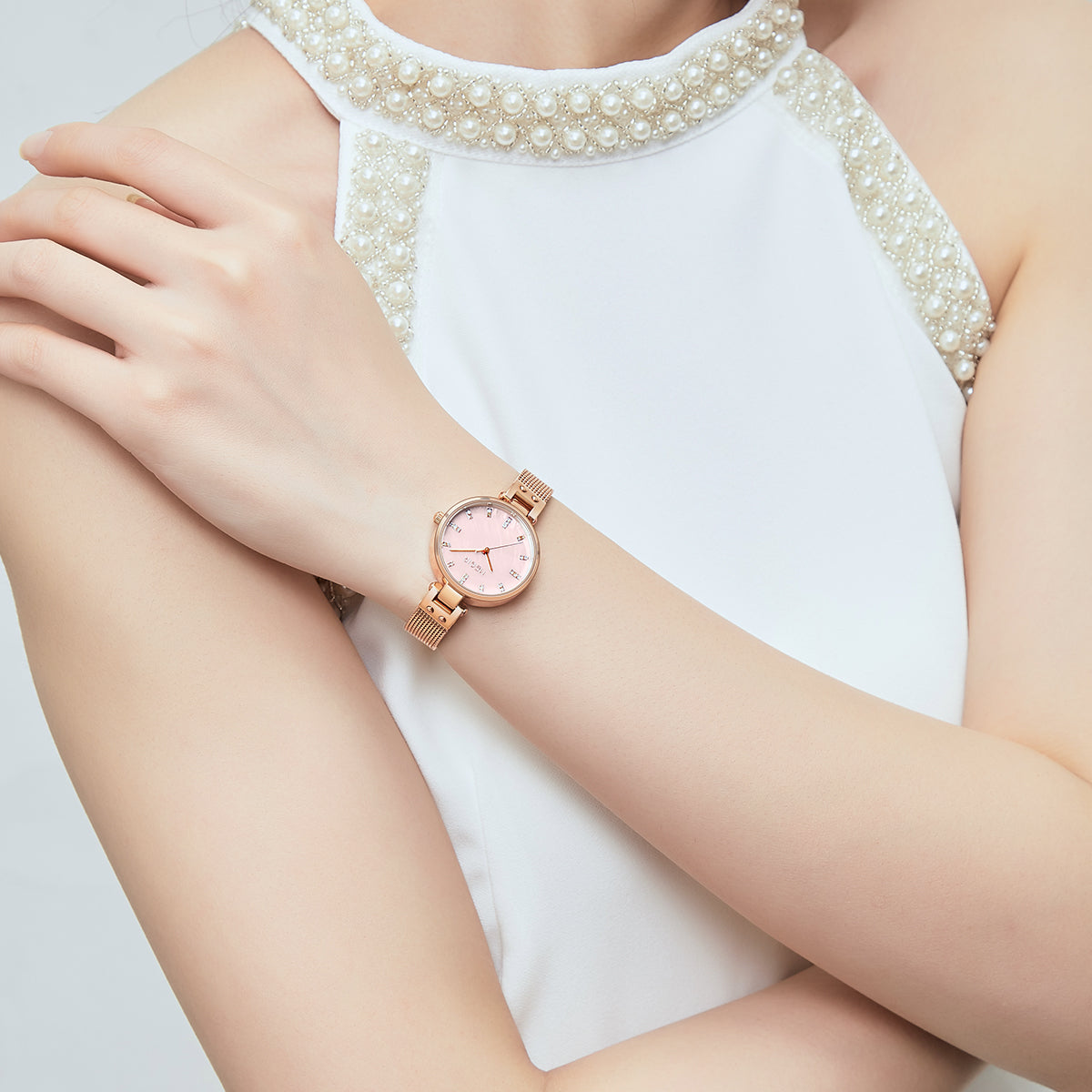 Elegant women's luxury quartz wristwatch with pink mother-of-pearl dial, crystal hour markers, rose gold mesh band, and water resistance