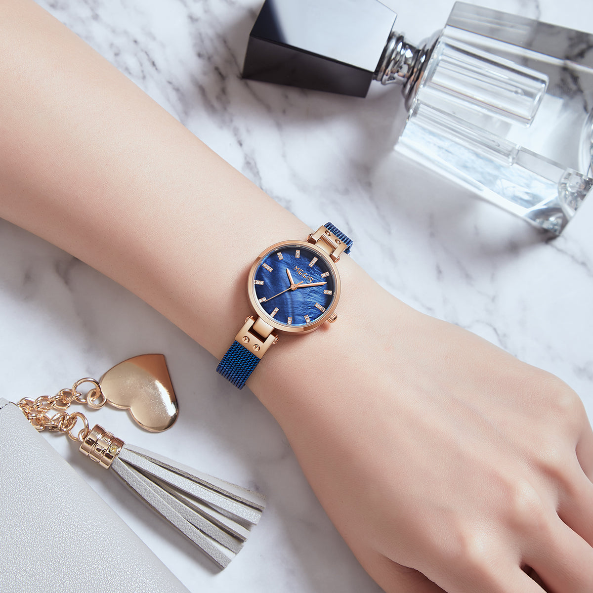 Elegant women's luxury quartz wristwatch with pink mother-of-pearl dial, crystal hour markers, rose gold mesh band, and water resistance