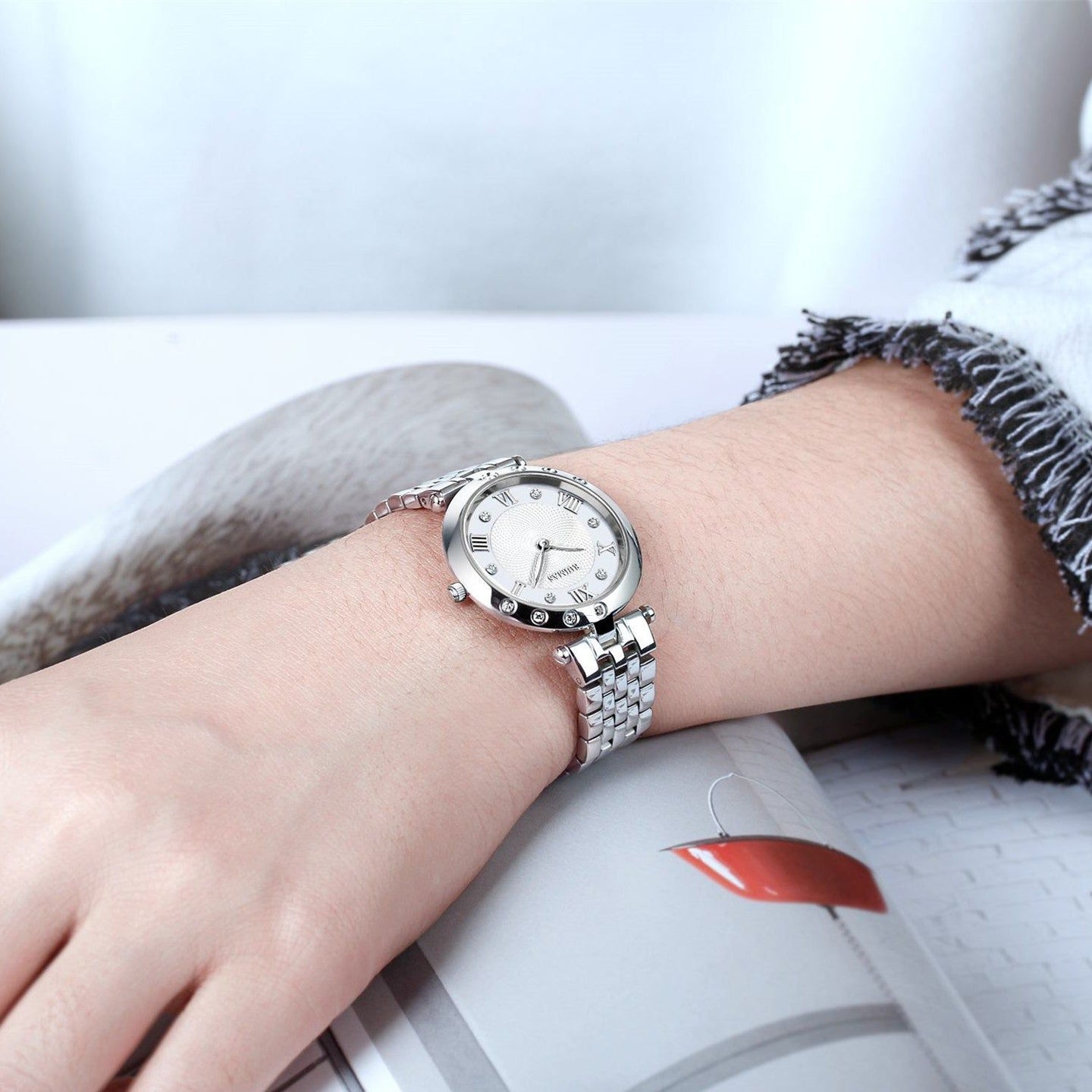 Silver luxury women's quartz bracelet watch with round face, crystal accents, Roman numerals, stainless steel band, elegant design