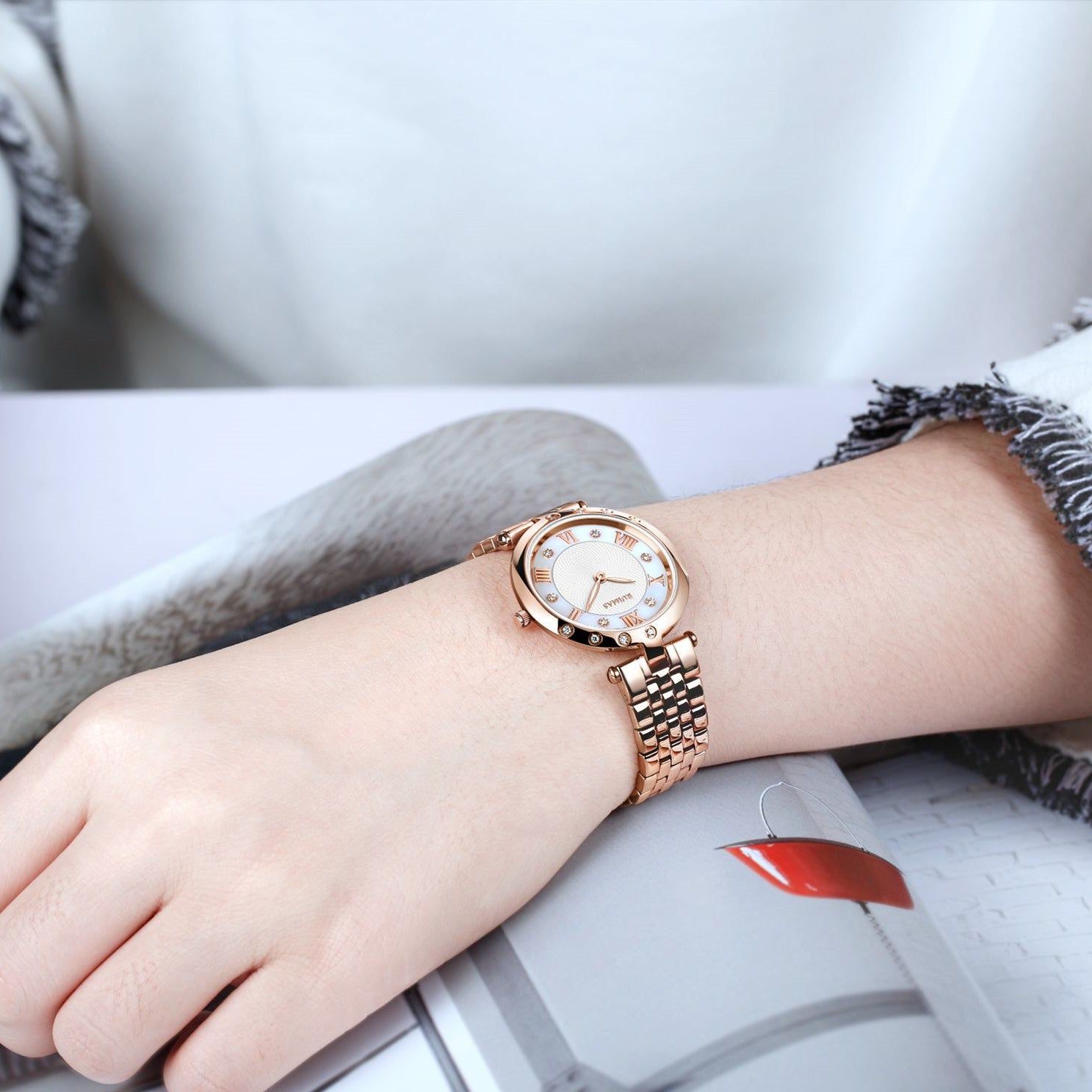 Silver luxury women's quartz bracelet watch with round face, crystal accents, Roman numerals, stainless steel band, elegant design