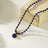 Elegant beaded necklace featuring deep blue lapis lazuli stones and gold accents with a round lapis lazuli pendant, perfect for sophisticated style.