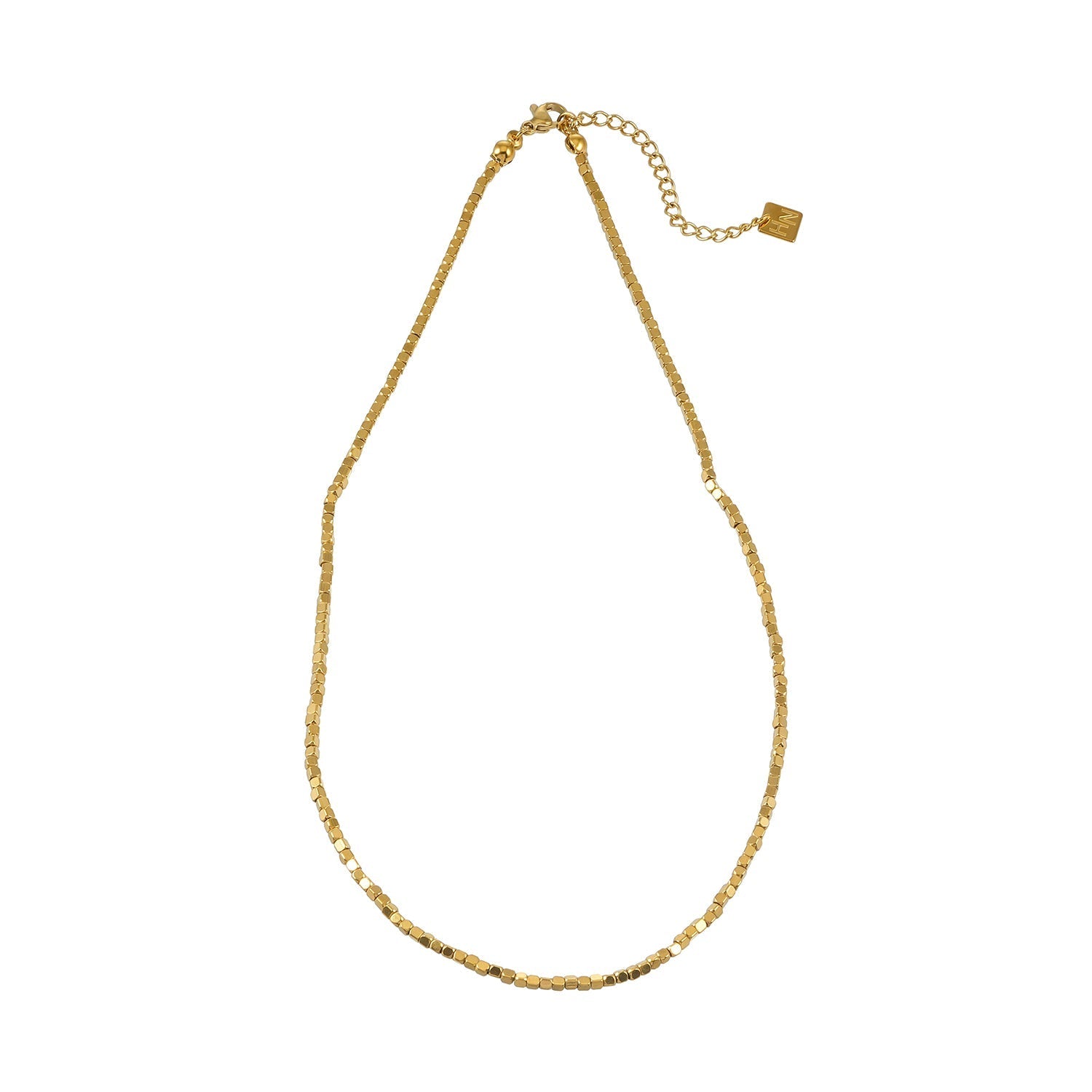 Gold beaded dainty chain necklace with small square beads, resting on a decorative ceramic dish with a scalloped edge, ideal for layering or everyday wear