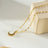Gold pendant necklace with a freshwater pearl center, surrounded by a halo of sparkling zirconia stones, on a delicate gold chain