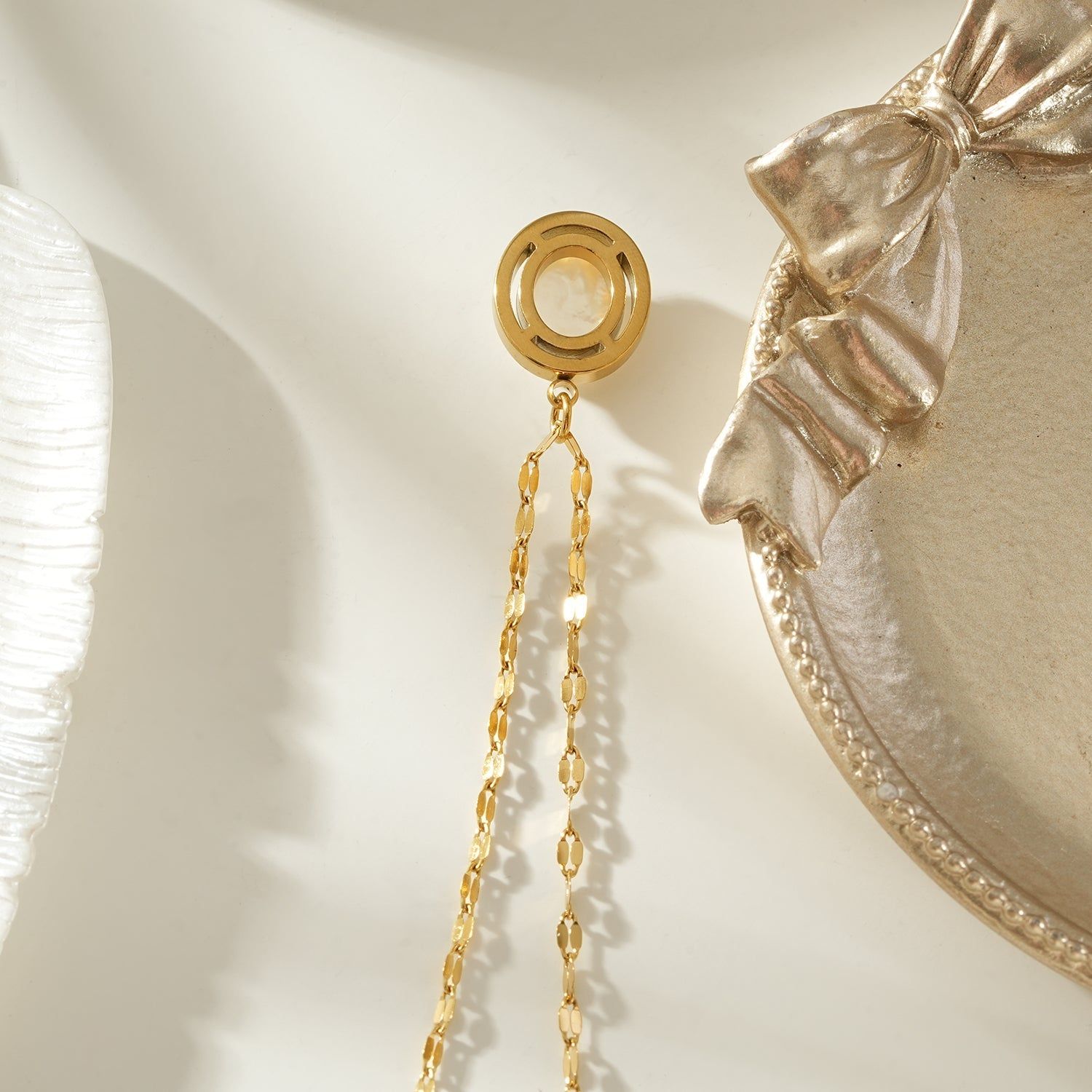 Gold pendant necklace with a freshwater pearl center, surrounded by a halo of sparkling zirconia stones, on a delicate gold chain