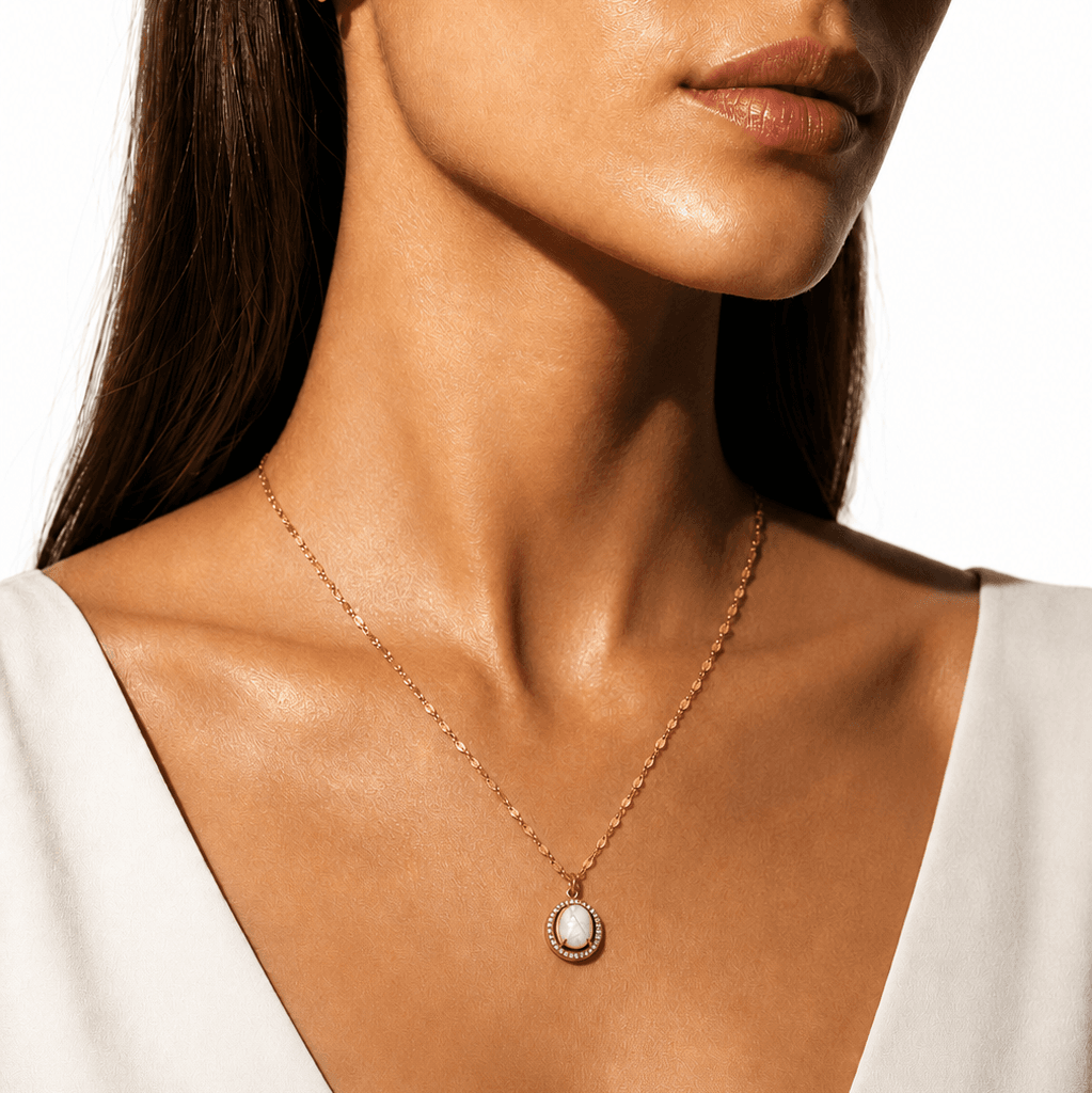Gold pendant necklace with a freshwater pearl center, surrounded by a halo of sparkling zirconia stones, on a delicate gold chain