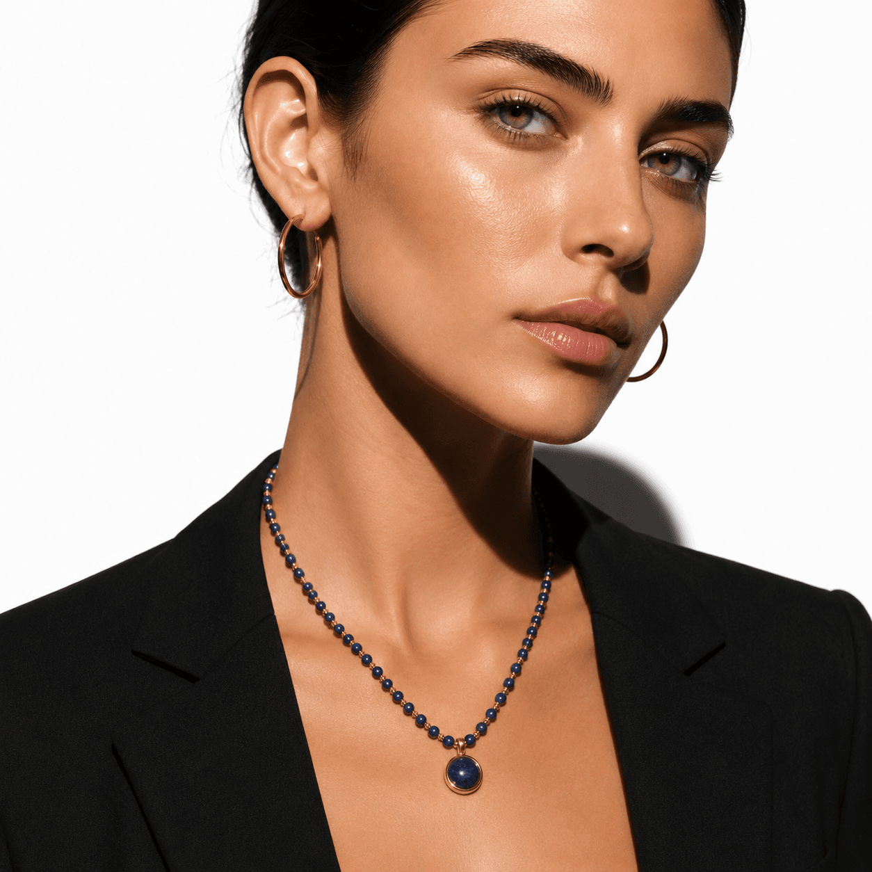 Elegant beaded necklace featuring deep blue lapis lazuli stones and gold accents with a round lapis lazuli pendant, perfect for sophisticated style.